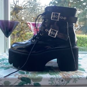 Black Patented High Heeled Platform Boots.Lace up with a side zipper.